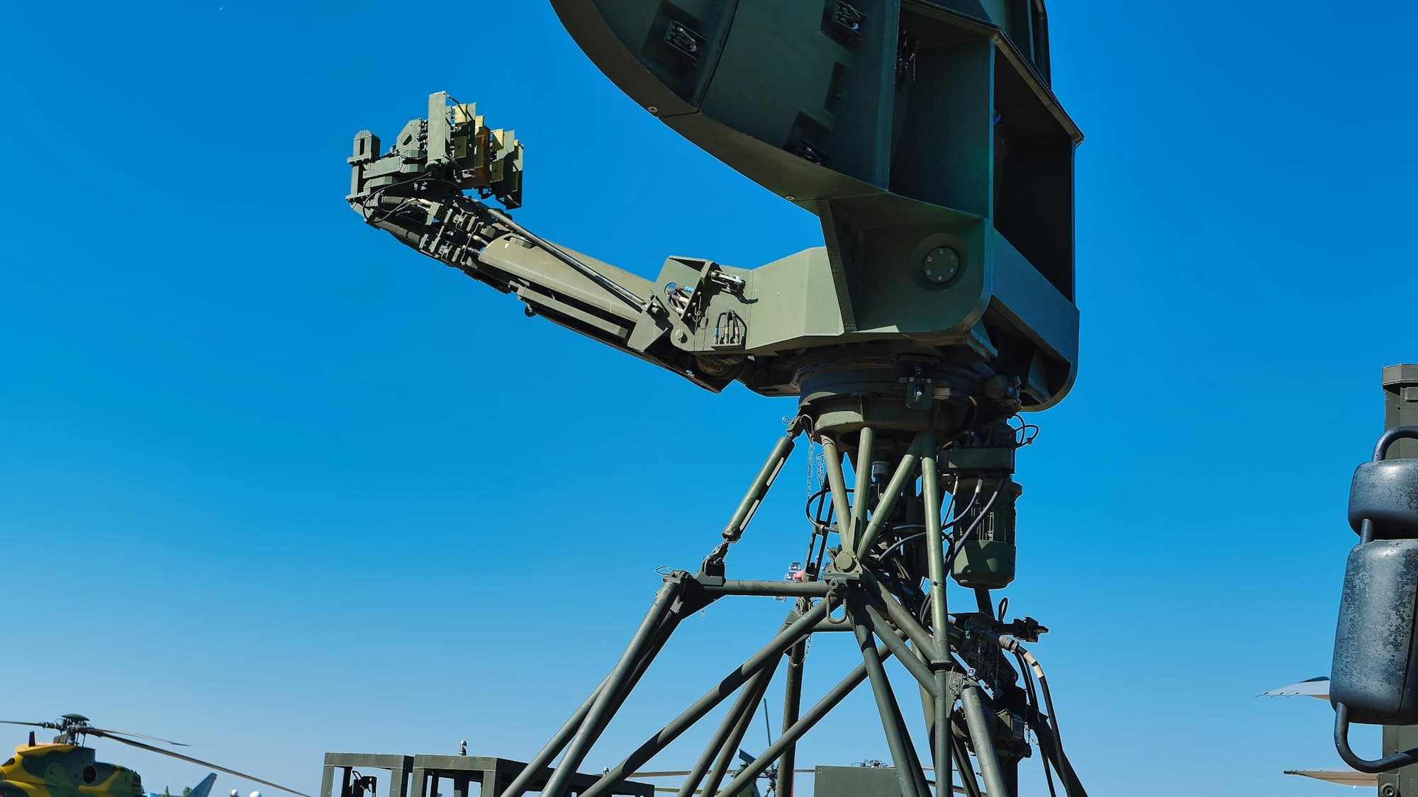 Military-style radar dish antenna against a blue sky